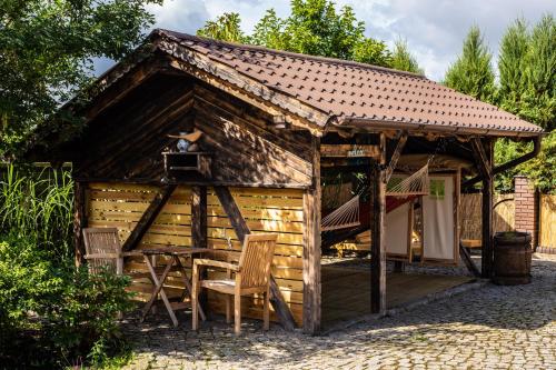 a wooden cabin with two chairs and a table at Na Dubie in Zalewo
