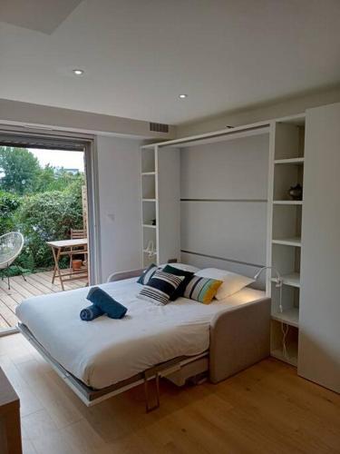 une chambre avec un grand lit et une grande fenêtre dans l'établissement Ty Jolie Super Grand Studio avec Parking et Terrasse, à Rennes