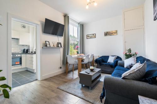 a living room with a couch and a table at Modern 3 bedroom apartment in Wimbeldon Park in London