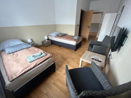 a small bedroom with two beds and a chair at Doppelzimmer mit TV in Meine