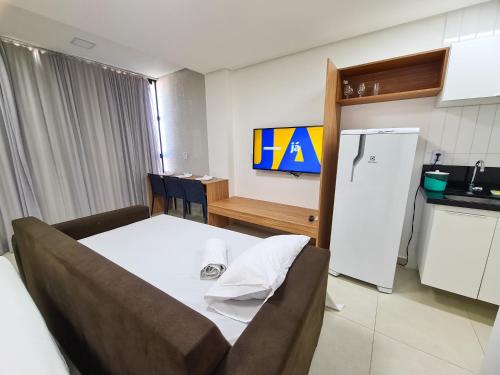a room with a couch and a kitchen with a refrigerator at Porto Star Prime By AFT in Porto De Galinhas