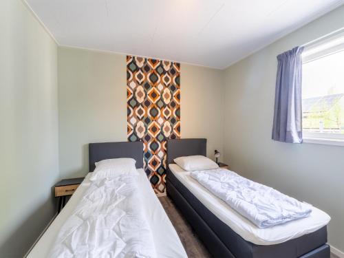 twee bedden in een kleine kamer met een raam bij Beautiful holiday home in Bantega with boat in Kuinre