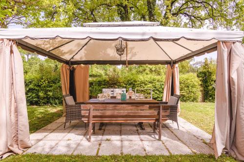 uma tenda com uma mesa de madeira e um banco em Il Cerretello - Tuscan Experience em Lucignano
