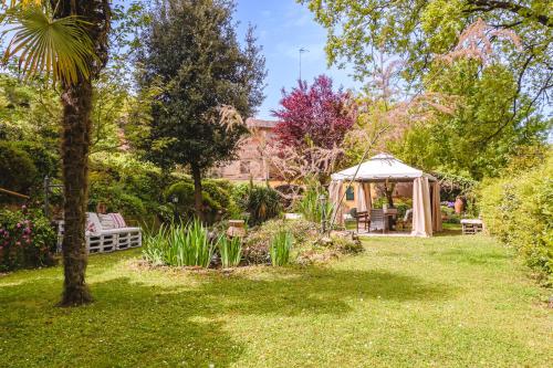um jardim com uma tenda e um gazebo em Il Cerretello - Tuscan Experience em Lucignano