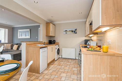a kitchen and living room with a counter and a table at Spacious garden apartment, sleeps 3 w/ parking - Owl Corner in Saint Leonards
