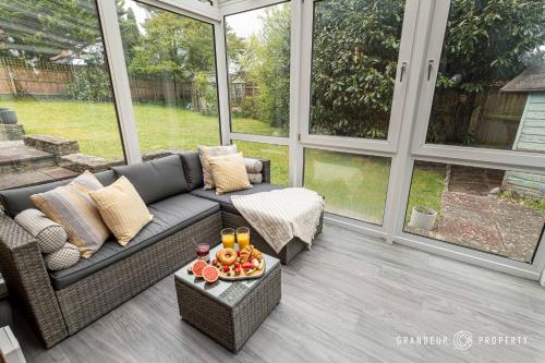 a screened in porch with a couch and a tray of fruit at Spacious garden apartment, sleeps 3 w/ parking - Owl Corner in Saint Leonards