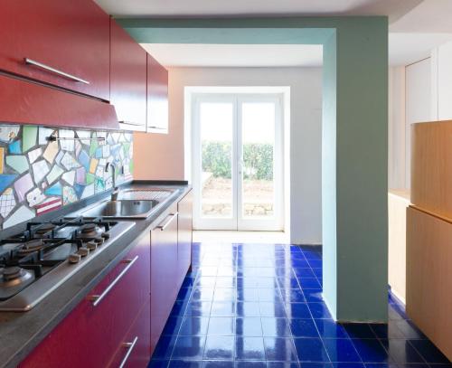 a kitchen with purple cabinets and a blue tile floor at Casa Tiberius Capri Retreat in Capri