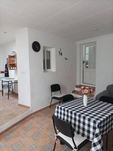Una sala de estar con una mesa con un jarrón de flores encima. en El Salero, en Villargordo del Cabriel