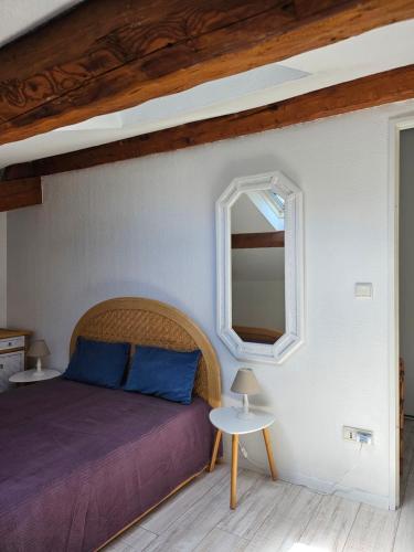 une chambre avec un lit et un miroir dans l'établissement SUQUET - BEACH 100m & PALAIS DES FESTIVALS 600m, à Cannes