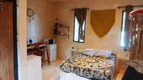 une chambre avec un lit et une cuisine avec une table dans l'établissement TulummiLucha, à Tulum