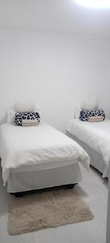 dwa łóżka siedzące obok siebie w pokoju w obiekcie Bon Sejour Guesthouse w mieście Okakarara