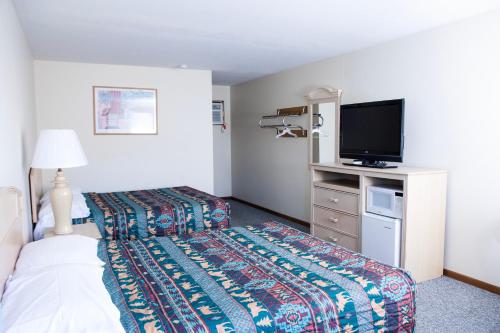 a hotel room with two beds and a flat screen tv at Starlite Motel in Wisconsin Dells