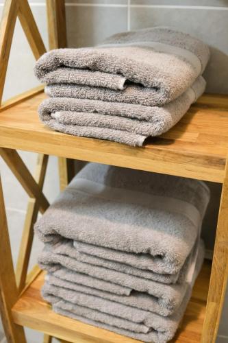 une pile de serviettes assises sur une étagère en bois dans l'établissement Jardin des Deux Rives, à Strasbourg