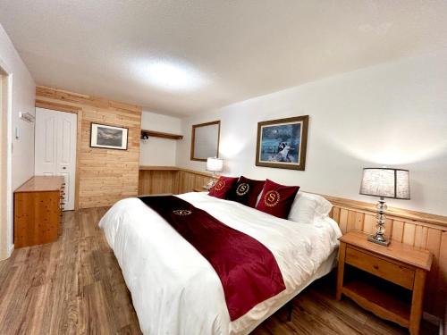 shangrila waterfront vacation home في Pender Island: غرفة نوم بسرير كبير ومخدات حمراء