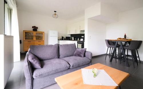 un salon avec un canapé violet et une table dans l'établissement Jardin des Deux Rives, à Strasbourg