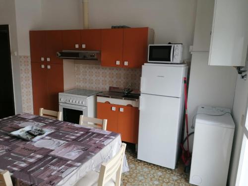 una pequeña cocina con nevera blanca y microondas en Appartamento dei Pavoni, en Punta Marina