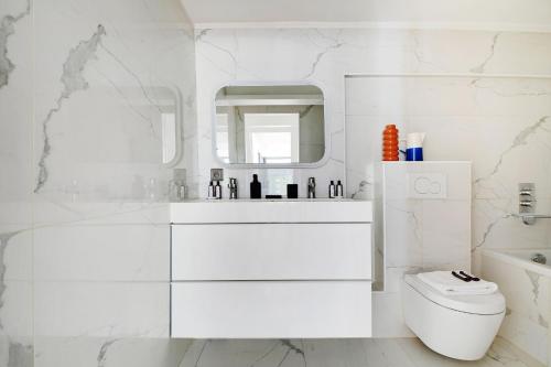 une salle de bain blanche avec un lavabo et des toilettes dans l'établissement Amazing Loft 2BR - Eiffel Tower, à Paris