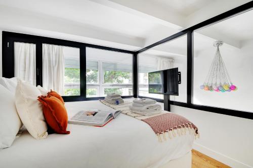 - une chambre avec un lit blanc, une télévision et des fenêtres dans l'établissement Amazing Loft 2BR - Eiffel Tower, à Paris