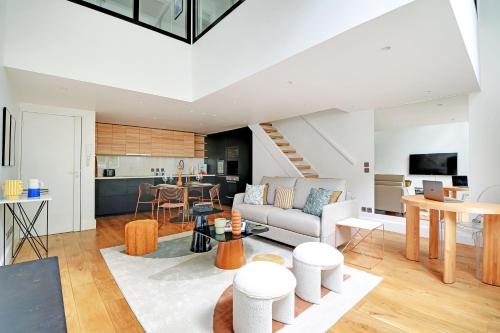 un salon avec un canapé et une table dans l'établissement Amazing Loft 2BR - Eiffel Tower, à Paris