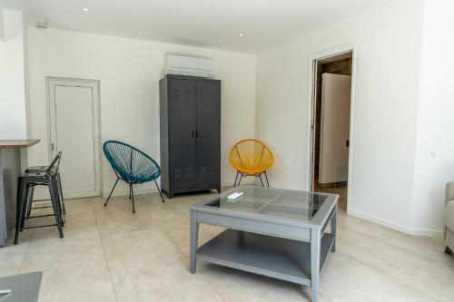 un salon avec deux chaises et une table dans l'établissement Provence - Studio classé 4 étoiles entre terre et mer - piscine, pétanque, à La Londe-les-Maures