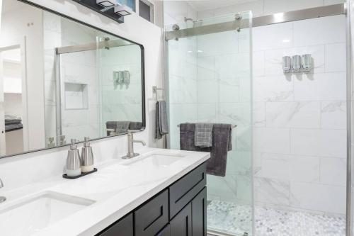 uma casa de banho branca com um lavatório e um chuveiro em Villa Palo Alto em East Palo Alto