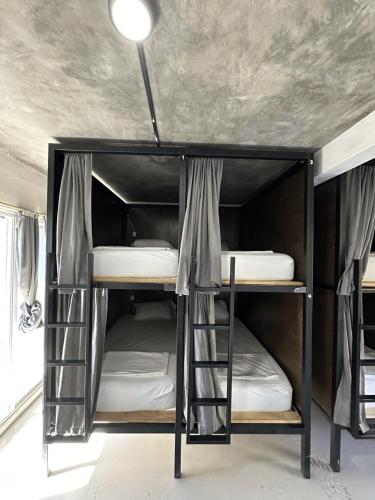 two bunk beds in a room with a ceiling at Straw Hat Surf Hostel & Bar in Brisas de Zicatela