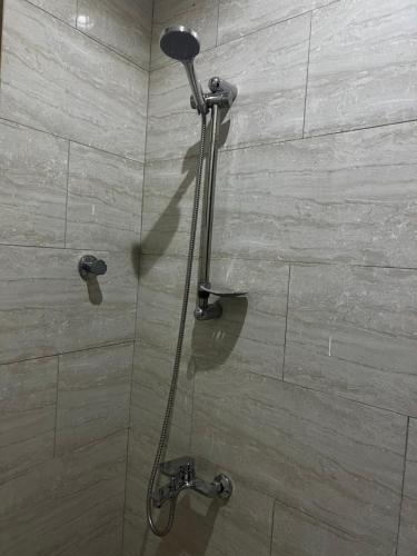 uma casa de banho com uma cabeça de chuveiro em شقة بدخول ذاتي غرفتين نوم وصالة em Al-Kharj