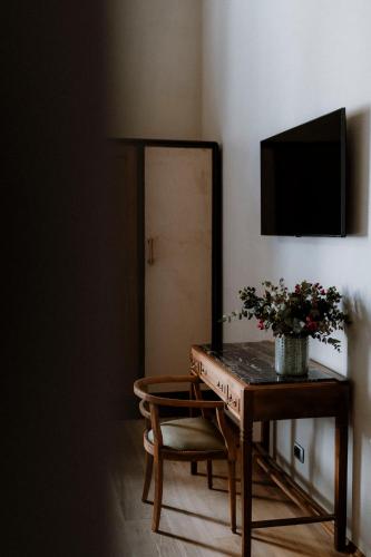 a room with a table and a chair and a mirror at ALMA bed & breakfast in Alba