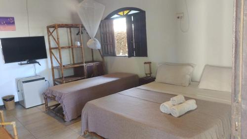 Habitación con 2 camas y TV. en Pousada Vila Imbassai en Imbassai