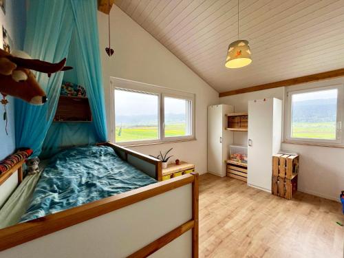 Schlafzimmer mit einem Bett mit blauem Baldachin in der Unterkunft Spacieuse maison avec jardin in Savagnier
