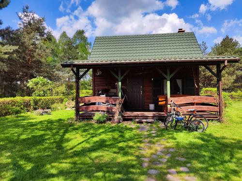 una pequeña cabaña con una bicicleta estacionada en el césped en Pożarowo domek na mazowszu, en Królewo