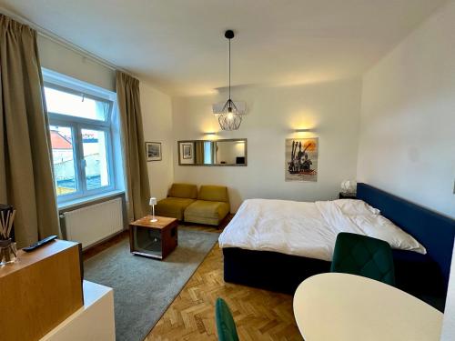 a bedroom with a bed and a couch at Modern studio in the heart of the city in Maribor