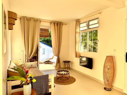 a living room with a couch and a window at Cottage Honoré Paradise in Deshaies