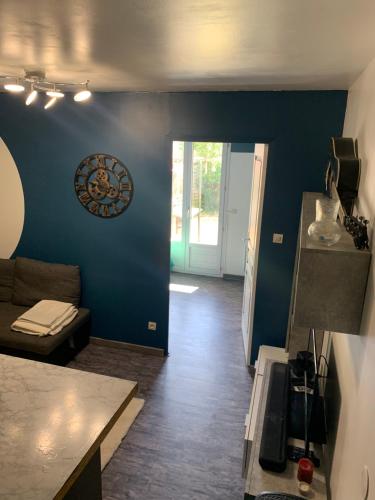 un salon avec un canapé et un mur bleu dans l'établissement Cosy avec jardin, à Quincy-Voisins