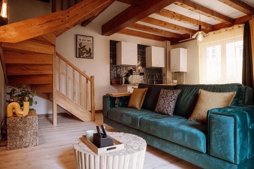 uma sala de estar com um sofá verde e uma mesa em Appart hôtel le 8 La Suite & Spa em Mâcon