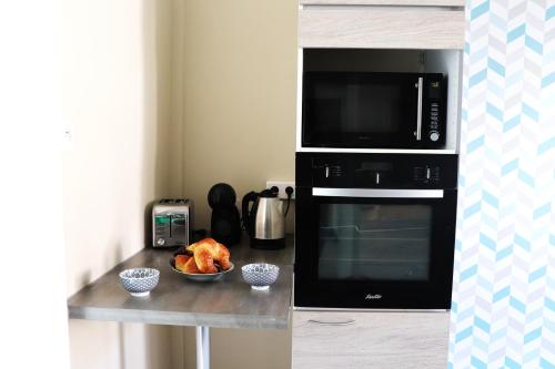 - une cuisine équipée d'un four micro-ondes et d'un bol de nourriture dans l'établissement LE REFUGE DES REVES, à Colmar