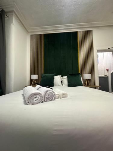 ein Schlafzimmer mit einem Bett mit Handtüchern darauf in der Unterkunft Tropical Heaven By Luxe Holiday Accommodation in Blackpool