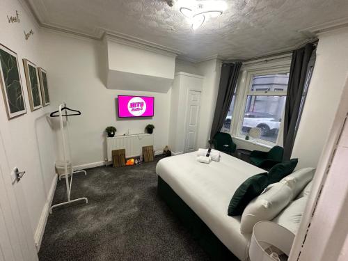 ein Schlafzimmer mit einem großen weißen Bett und einem Fenster in der Unterkunft Tropical Heaven By Luxe Holiday Accommodation in Blackpool