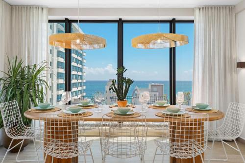 ein Esszimmer mit einem Tisch und Stühlen sowie einem großen Fenster in der Unterkunft HiBird- Apartment and Suites Hotel in San Juan