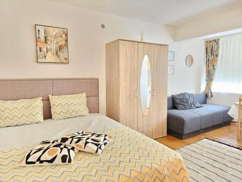 een slaapkamer met een bed en een bank bij Studio Asli in Budva