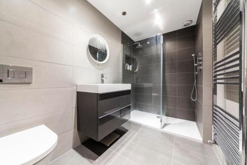 y baño con lavabo y ducha. en TMW guest house en Thamesmead