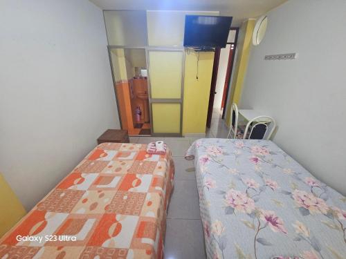 2 łóżka pojedyncze w pokoju z korytarzem w obiekcie Su Majestad II w mieście Huanta