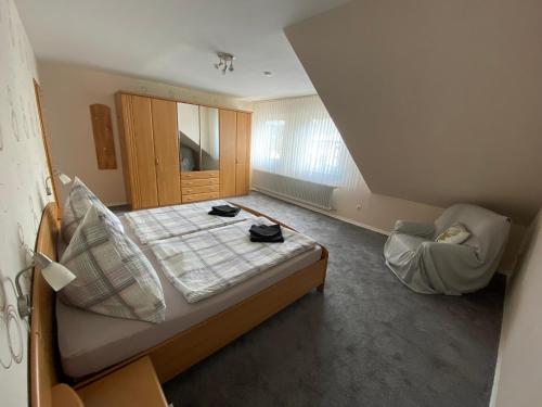 ein kleines Schlafzimmer mit einem Bett und einem Stuhl in der Unterkunft Ferienwohnung Becker in Ellenz-Poltersdorf