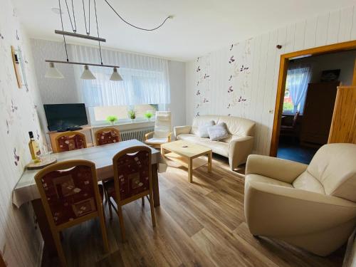 ein Wohnzimmer mit einem Sofa und einem Tisch in der Unterkunft Ferienwohnung Becker in Ellenz-Poltersdorf