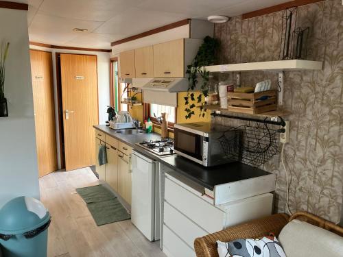 een kleine keuken met een magnetron op een aanrecht bij Beach house in Zandvoort