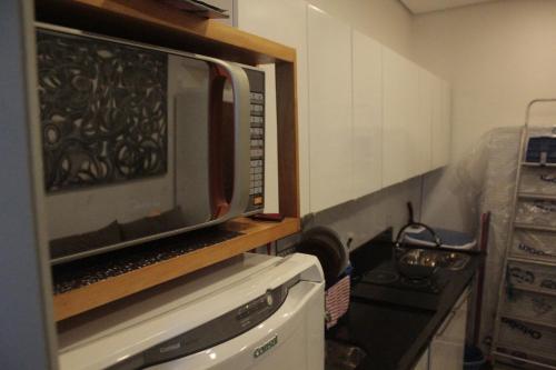 a microwave sitting on top of a stove in a kitchen at Kitnet no Centro de Porto Alegre in Porto Alegre