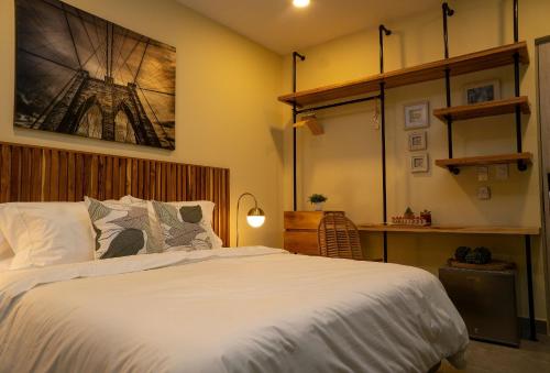 Schlafzimmer mit einem großen weißen Bett und einem Schreibtisch in der Unterkunft Casa Ramona : Suites Boutiques en Cartagena de Indias in Cartagena de Indias