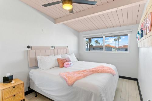 a bedroom with a bed with a pink blanket on it at California Dreamin in Oceanside