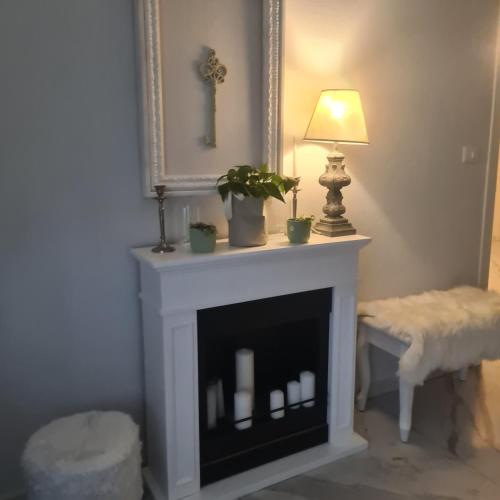 a living room with a fireplace with a lamp and a mirror at Cascina Antiche Terre in Campegine
