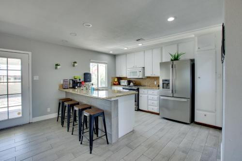 a kitchen with white cabinets and a counter with bar stools at Las Vegas Retreat with Yard Less Than 5 Mi to Strip! in Las Vegas